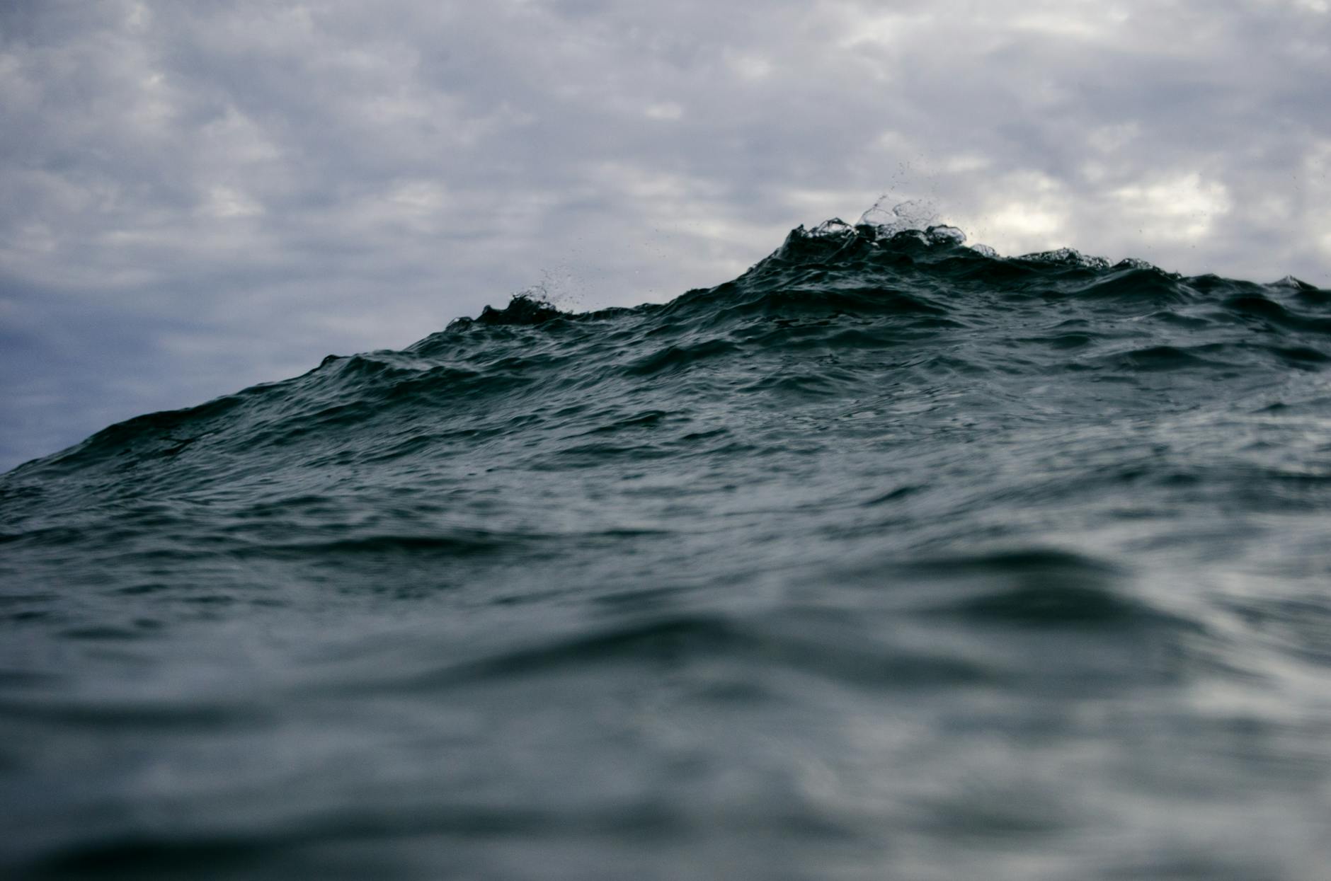 ocean waves under white clouds